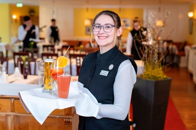 lächelnde Frau mit Tablett im Restaurant