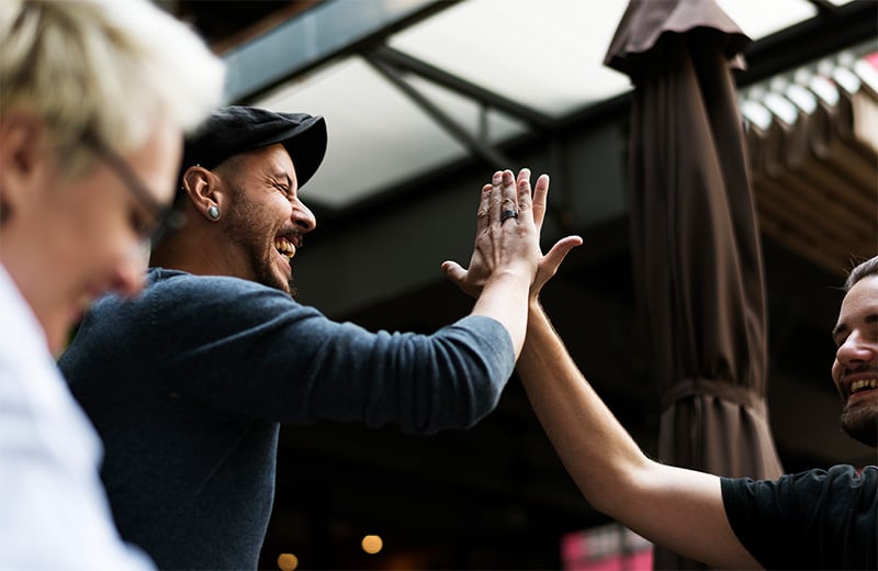 zwei Menschen geben sich ein High Five